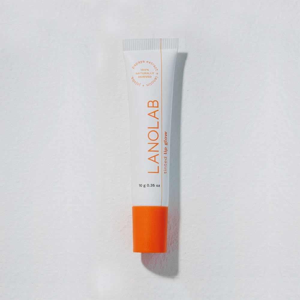 Lanolab tube with orange lid on white surface