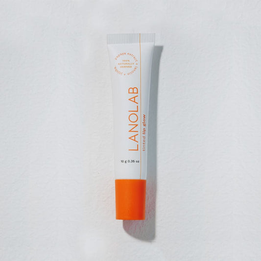 Lanolab tube with orange lid on white surface