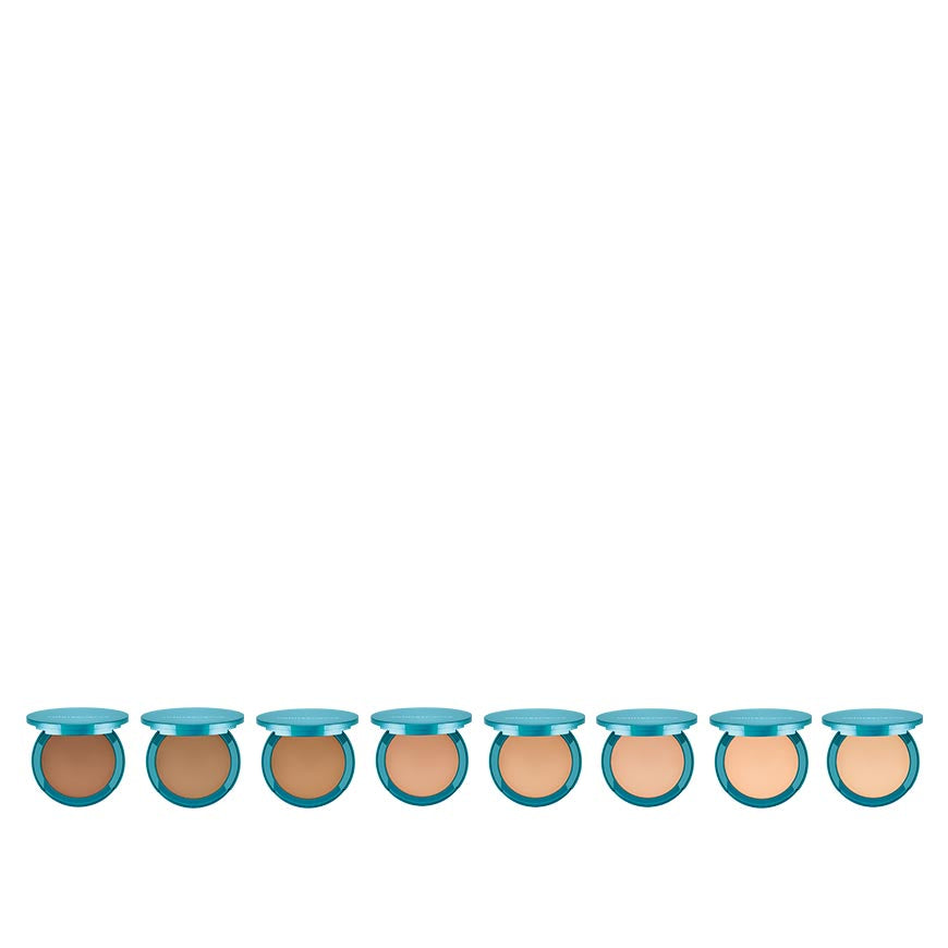 A collection of twelve pressed foundation bottles, with a light beige to dark brown color range, each with a blue cap.