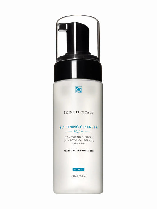 A pump bottle of SkinCeuticals Soothing Cleanser with makeup brushes in the background.